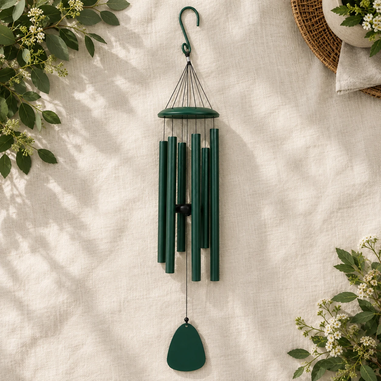 Six-tube evergreen wind chime laid out on linen
