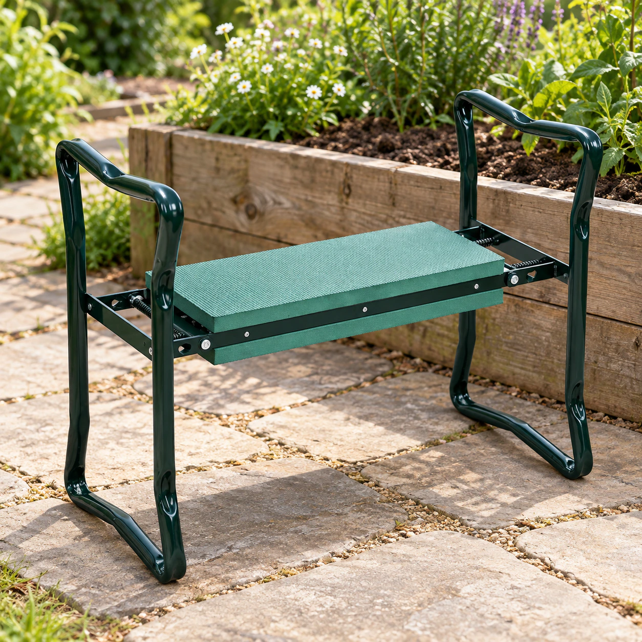 Green folding garden kneeler beside a planted raised bed