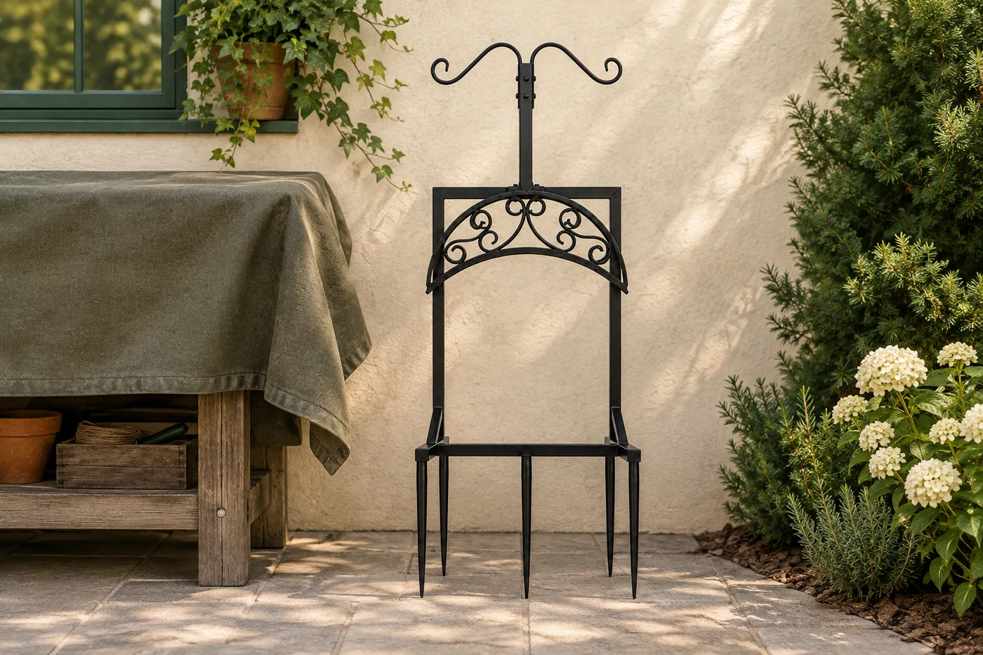 Scroll hose stand beside a covered garden workbench